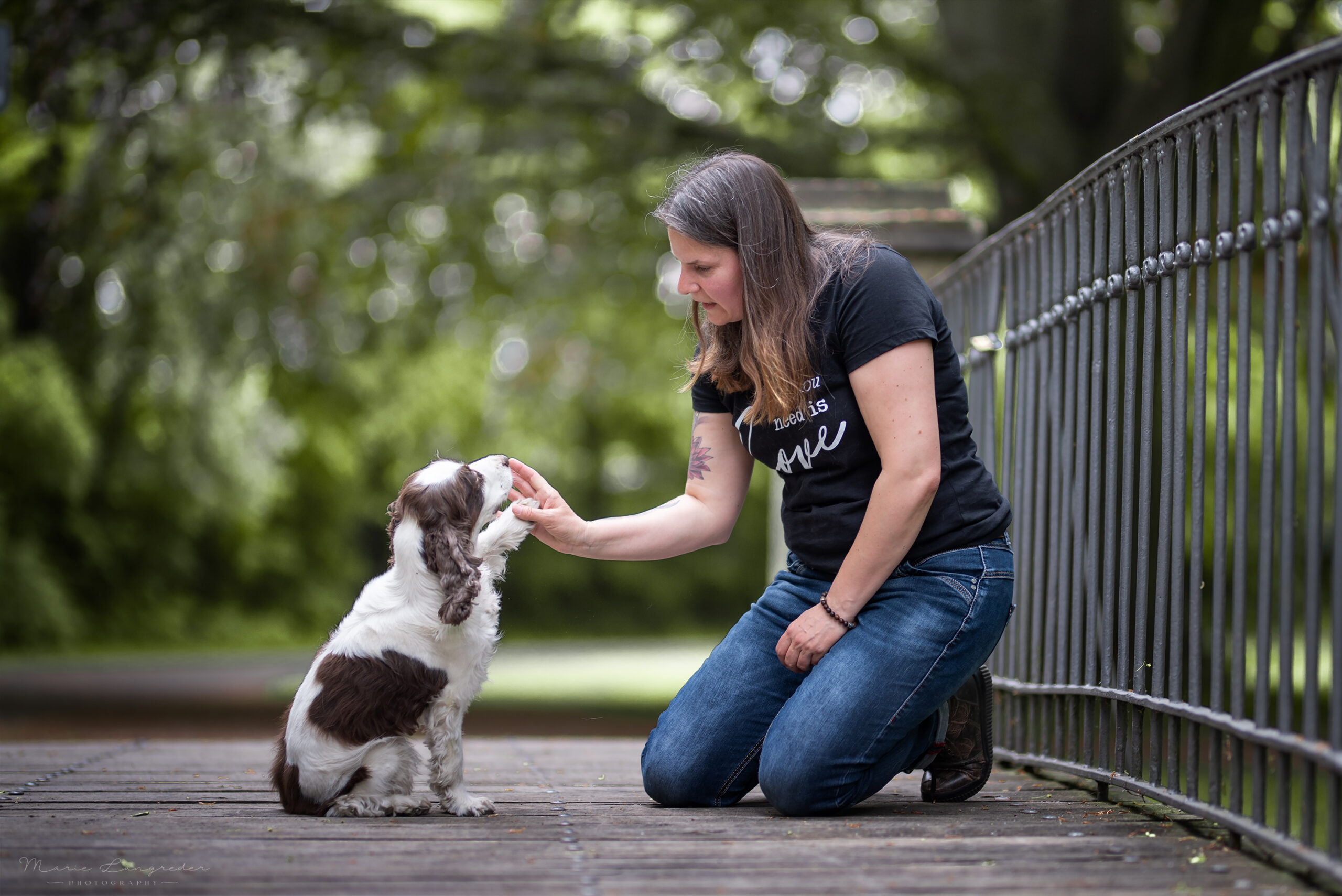 Maike Fügner mit ihrer pfotegebenden Cocker Spaniel Hündin auf einer Brücke